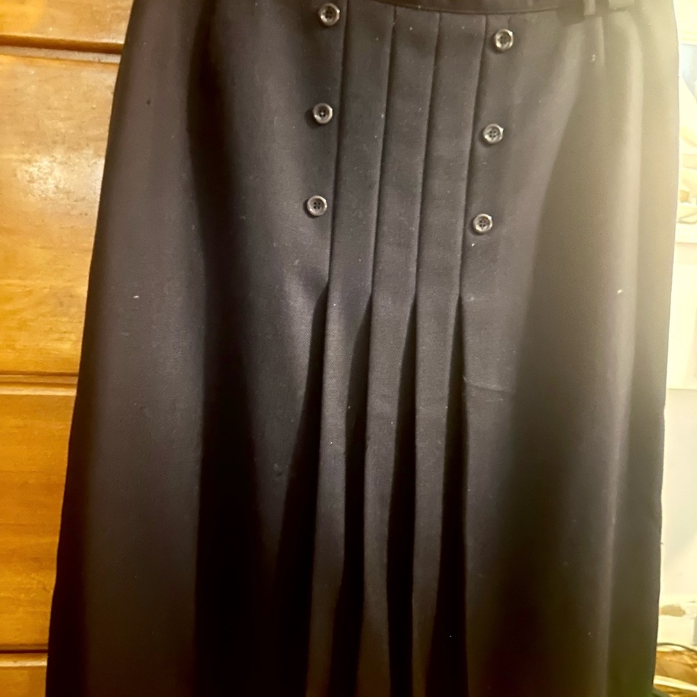 Navy Blue Buttoned and pleated in front, loops for belt. Tailored lined skirt.